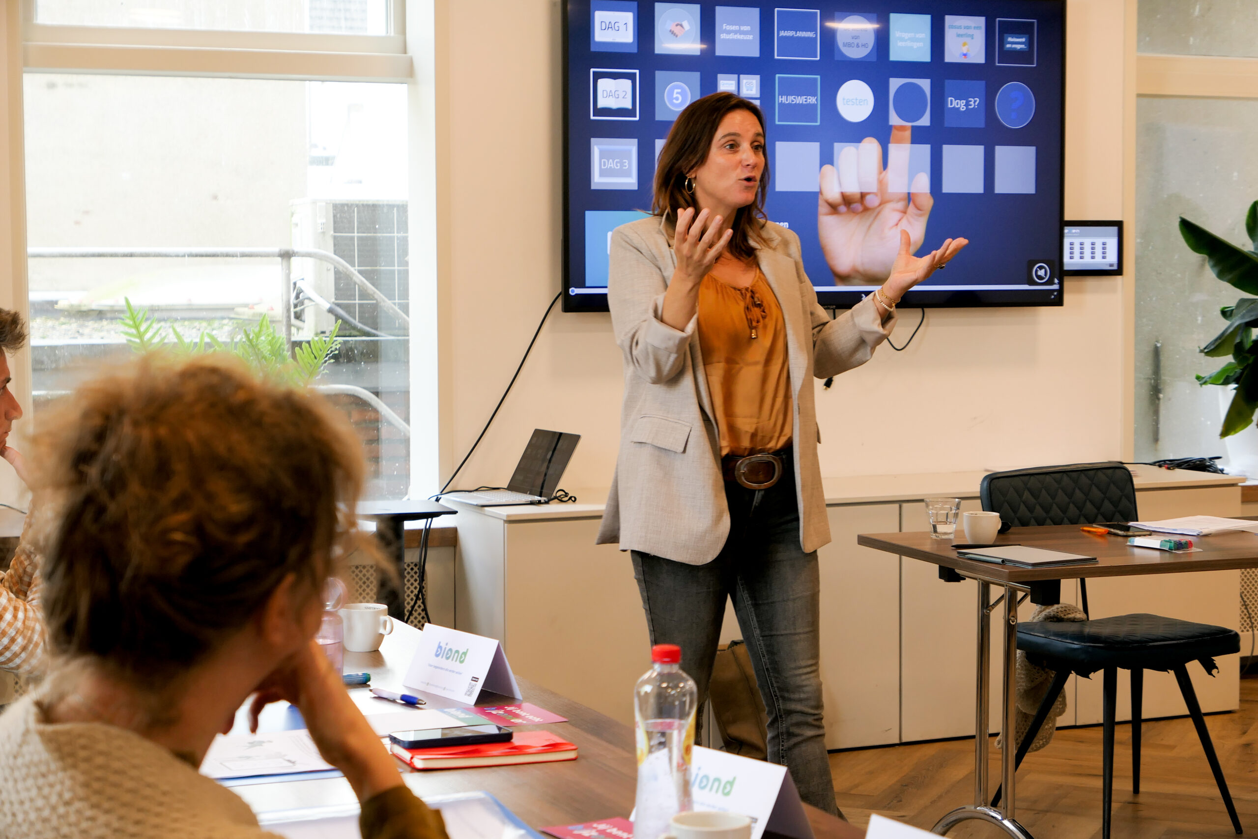 Trainer Martine Buijsen bij Se7en die een groep startende decanen traint.