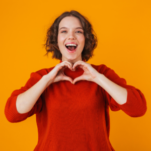 jonge vrouw vormt een hartje met haar handen