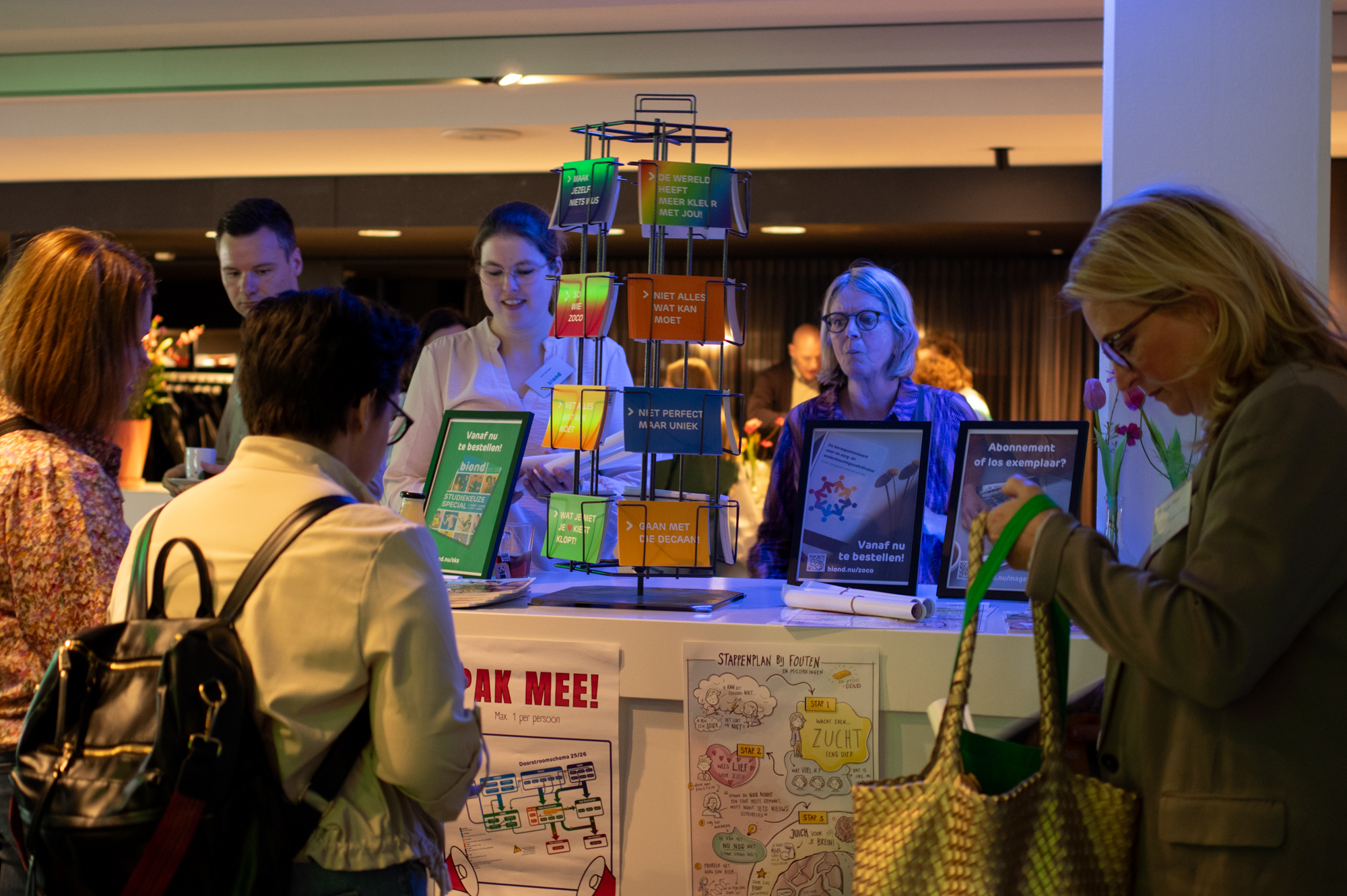 BiOND stand met mensen die posters en kaarten pakken